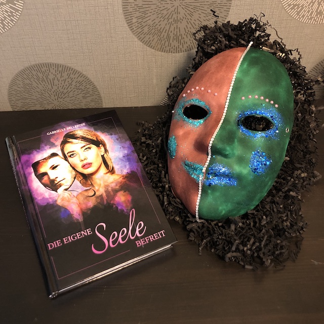 Die eigene Seele befreit von Gabrielle Bellerose Maske mit Buch liegend