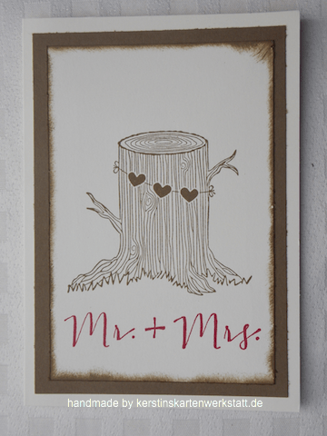 Grußkarte zur Hochzeit. Abgebildet ist ein Baumstumpf an dem einen Kette mit drei Herzen hängt. Darunter stehen die Worte Mr. + Mrs. in rot gestempelt. 