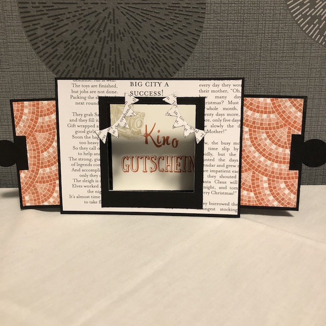 Selbst gebastelte Ziehkulissenkarte als Gutschein für einen Kinobesuch. Die Karte kann man rechts und links an den schwarzen Kreisen auseinander ziehen. So geht der Vorhang auf und dahinter erscheint der Text für den Gutschein.