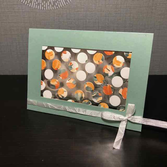 Karten Projekt: Mach was draus. Die Karte ist zum Teil Transparent. Auf der Folie sind Kreise aufgeklebt. Als kleines Accessoire ist ein Band am unteren Rand angebracht. Die selbstgebastelte Grußkarte besteht aus Material von Stampin Up.