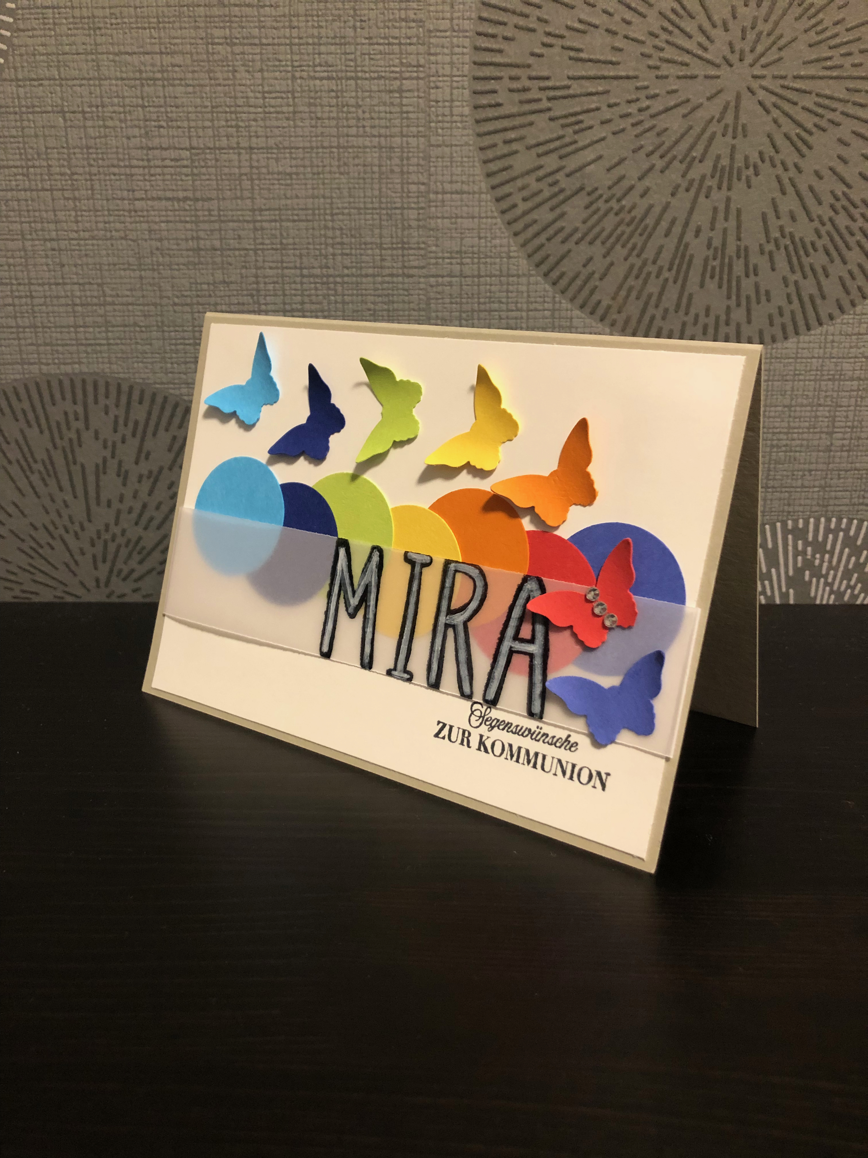 Kommunionskarte mit Kreisen und Schmetterlingen in Regenbogenfarben