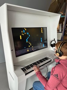 Ich sitze am Klavier in der I AM AI Sonderausstellung in der Phaeno WOlfsburg