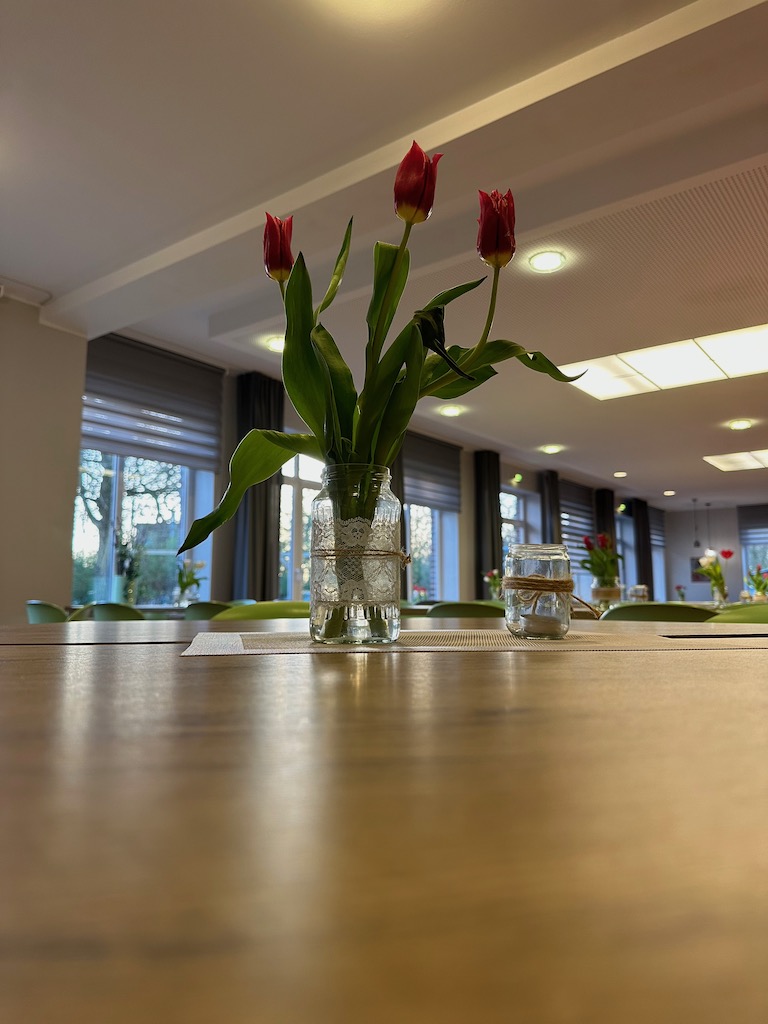Essenssaal in der Jugendherberge Jever mit Frühlingsdeko in Form von kleinen Tulpensträußen auf den Tischen