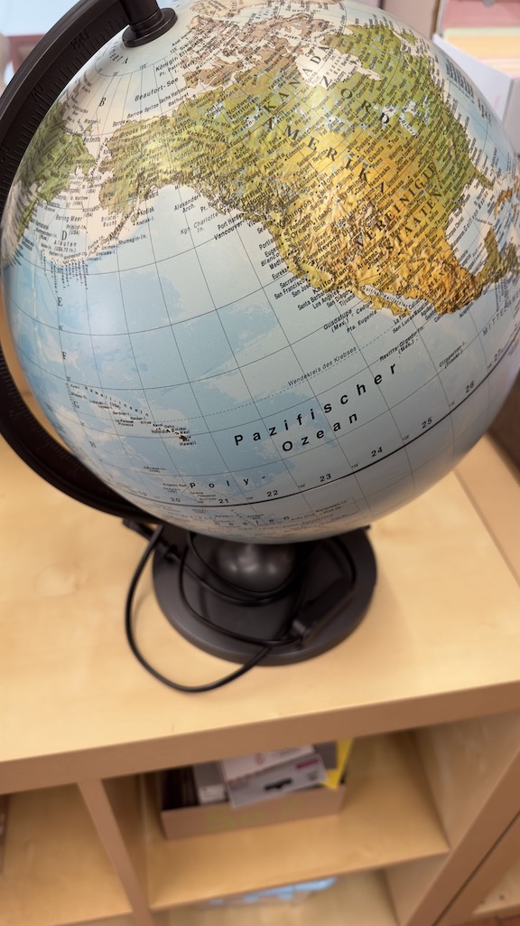 Globus bzw. Weltkugel in weiß und gold angemalt dient als Gästebuch für eine Hochzeit