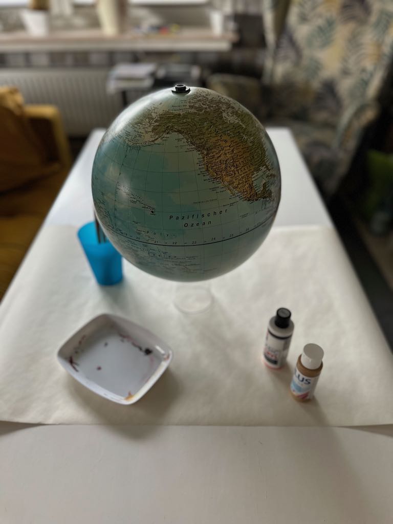 Globus bzw. Weltkugel in weiß und gold angemalt dient als Gästebuch für eine Hochzeit