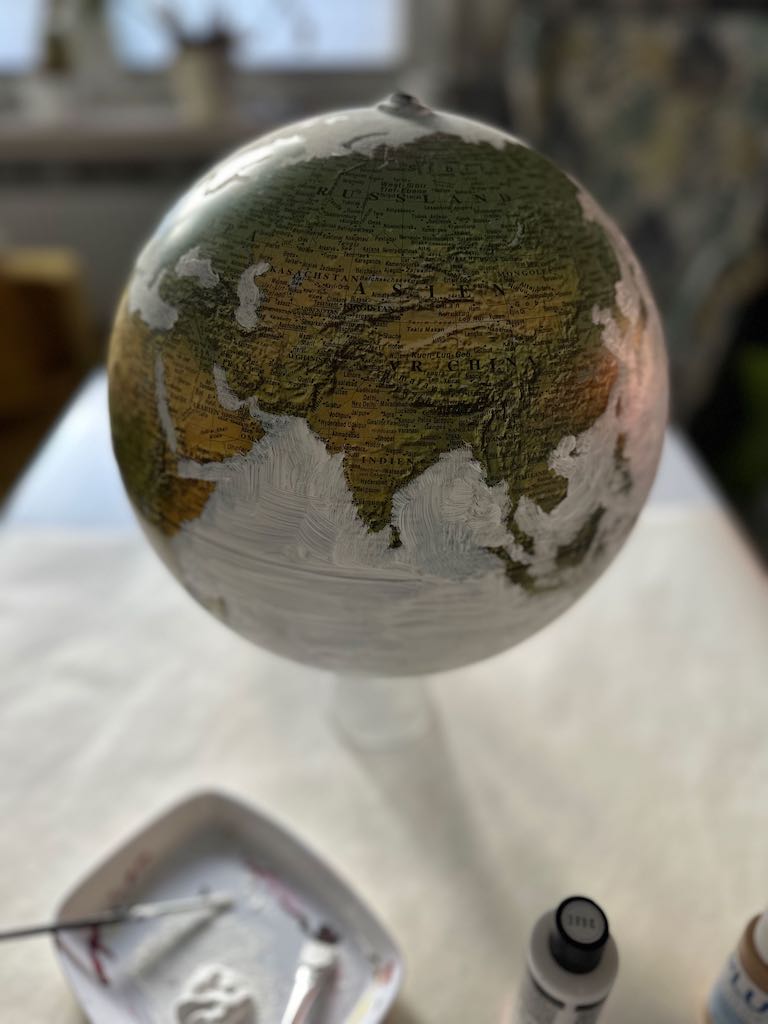 Globus bzw. Weltkugel in weiß und gold angemalt dient als Gästebuch für eine Hochzeit