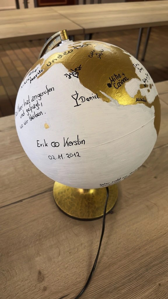 Globus bzw. Weltkugel in weiß und gold angemalt dient als Gästebuch für eine Hochzeit