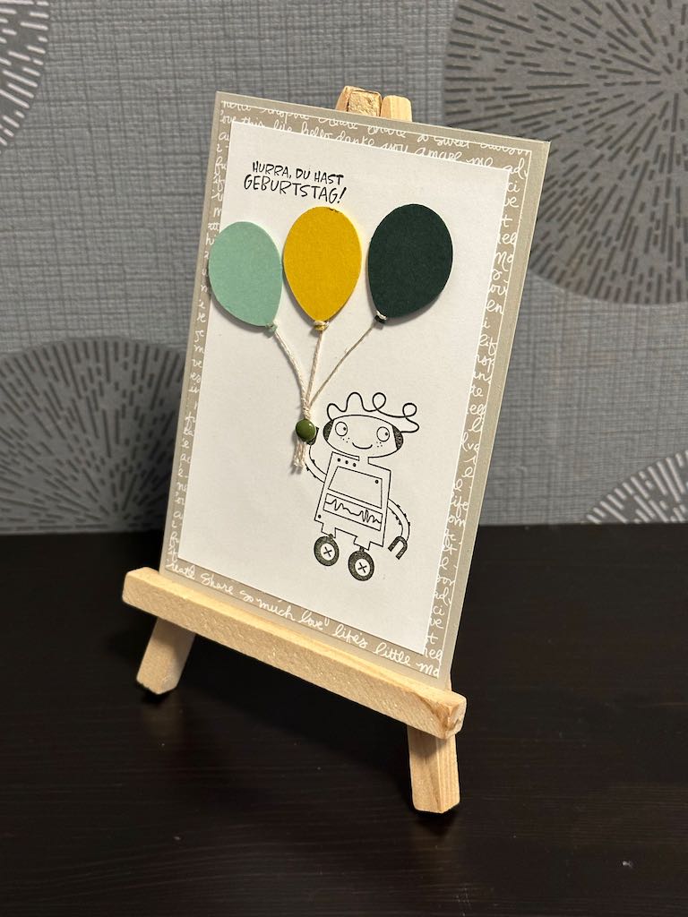 Geburtstagskarte für Kinder mit dem Spruch: Hurra, du hast Geburtstag. Und einem Roboter, der Luftballons in der Hand hält