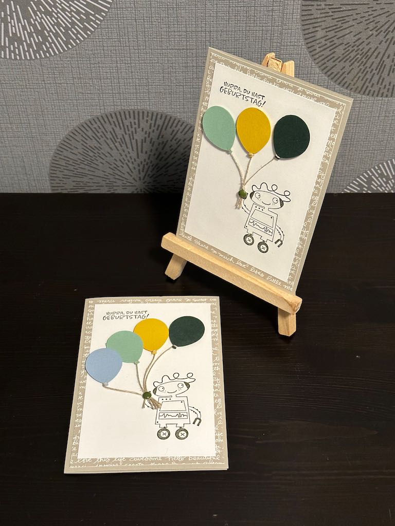 Geburtstagskarte für Kinder mit dem Spruch: Hurra, du hast Geburtstag. Und einem Roboter, der Luftballons in der Hand hält