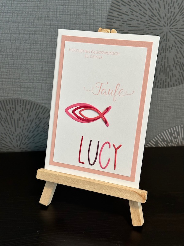 Glückwunschkarte zur Taufe von einem Mädchen mit Fischen und ihrem Namen in ausgestanzten Buchstaben.