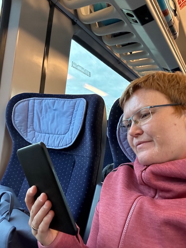 Ein Foto von der Buch Berlin 2023. Kerstin beim Lesen auf der Rückfahrt