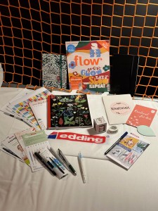 Goodie Bag vom Journaling Barcamp 2023 in Hamburg. Von folgenden Sponsoren sind Produkte und Informationen in der Goodie Bag: folia Bringmann, sigel, Jolie, Pentel, Sketch Stuff, flow, punktgenau Verlag, Moleskine, mitp Verlag und inkblot.de