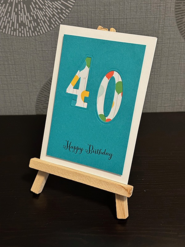Geburtstagskarte in Bermudablau zum 40. Geburtstag. Die 40 ist in großen Ziffern ausgestanzt und mit einem Designpapier hell hinterlegt. Unter der 40 ist Happy Birthday gestempelt.