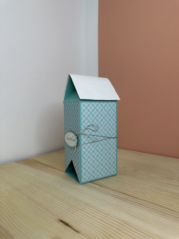 Eine Box, die an ein Haus erinnert. Das Dach kann man oben aufklappen, es ist nur durch einen Magneten zusammengehalten. Unten ist eine Dreiecköffnung zu sehen, aus der die Teebeutel entnommen werden können. Ein kleines Teehaus gebastelt mit Stampin Up Material
