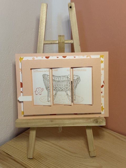 Sliderkarte zur Geburt eines Mädchens mit Babywiege. Zu sehen ist eine Karte in rosa, die man seitlich ziehen kann und dann das Bild von der Babywiege verschwindet und der Name des Kindes dahinter hervor kommt. Gebastelt von Kerstins Kartenwerkstatt