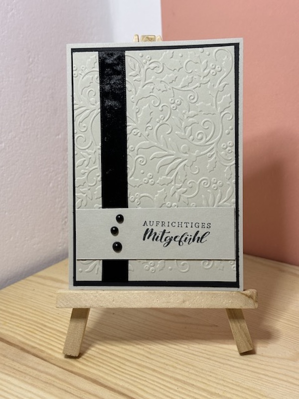 Trauerkarte in braun (Savanne) und schwarz mit dem Schriftzug: Aufrichtigers Mitgefühl. Auf dem geprägten Hintergrund ist senkrecht ein schwarzes Band angebracht.