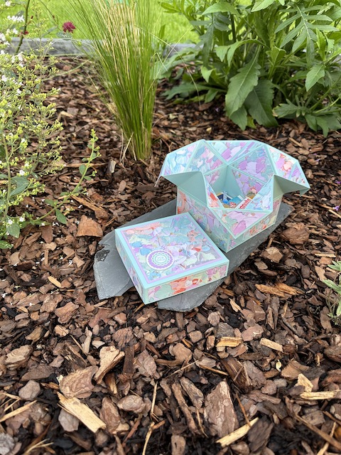 Zu sehen ist eine offene Napkin Fold Box gebastelt von Kerstins Kartenwerkstatt mit Material von Stampin Up. Die Besondere Faltung der Box kommt nach öffnen des Deckels zum Vorschein.