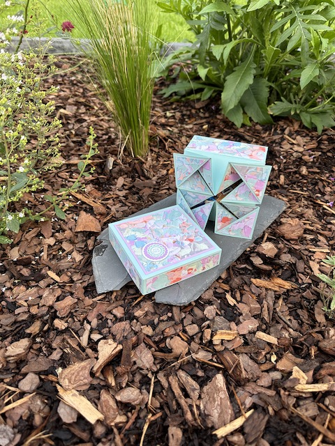 Zu sehen ist eine offene Napkin Fold Box gebastelt von Kerstins Kartenwerkstatt mit Material von Stampin Up. Die Besondere Faltung der Box kommt nach öffnen des Deckels zum Vorschein.