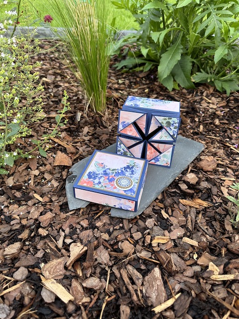 Zu sehen ist eine offene Napkin Fold Box gebastelt von Kerstins Kartenwerkstatt mit Material von Stampin Up. Die Besondere Faltung der Box kommt nach öffnen des Deckels zum Vorschein.