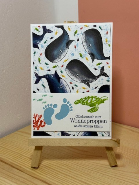 Zu sehen ist eine Glückwunschkarte zur Geburt. Auf der Babykarte ist der Spruch: "Glückwunsch zum Wonneproppen an die stolzen Eltern" gestempelt. Der Hintergrund ist durch das Designpapier mit Meerestieren einfach bunt und kann sowohl für Mädchen, als auch für Jungen verschenkt werden.