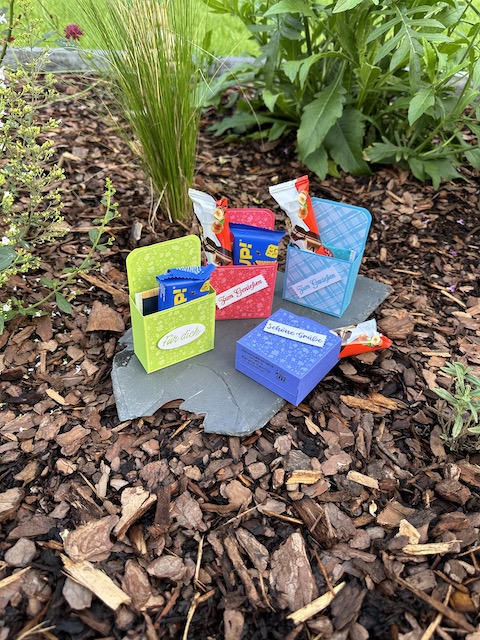 Zu sehen ist eine kleine Verpackung aus Material von Stampin Up. Das kleine MItbringsel kann mit Süßigkeiten und Teebeutel gefüllt werden. Exemplarisch sind auf dem Foto Hanuta, Bueno und Tee zu sehen, um ein größen Verhältnis für die Verpackung zu bekommen.