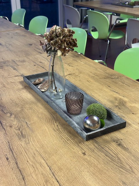 Zu sehen ist ein Dekorations Tablett mit getrockneter Hortensie, einem Teelicht und etwas Holz