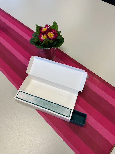 Zu sehen ist eine gebastelte Box mit zwei Fächern. Eins wird aufgeklappt in dem zweiten ist eine Schublade. Doppelte Box