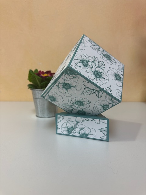 Würfel für Fotos, der auf einer dreieckigen Box steht