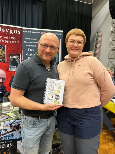 Zu sehen ist ein Foto von Dirk Osygus mit meiner Lesetagebuchseite zu Selbstvergeltung in der Hand und ich selbst in Osnabrück auf der Buch Osnabrück 2025