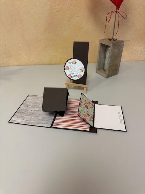 Zu sehen ist eine selbstgebastelte Karte mit doppelten Wow Effekt mit Material von Stampin Up. Beim öffnen bewegt sich ein kleiner Teil in der Mitte der Karte und an der rechten Seite kann man ziehen und dann klappt eine zweite Karte automatisch auf. 