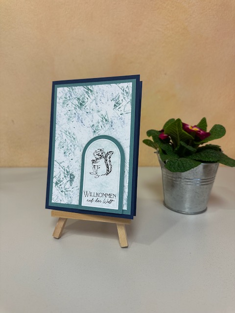 Zu sehen ist eine Karte in blau als Glückwunschkarte zur Geburt. Der Hintergrund wurde mit der Taschentuch-Tupf-Technik gestaltet.