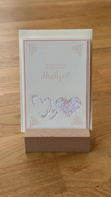 Zu sehen ist eine Einladungkarte zur Hochzeit mit Herzen