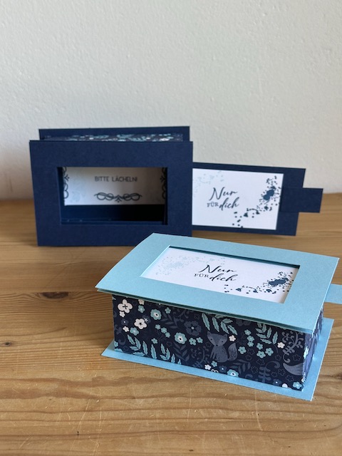 Zu sehen ist eine handgemachte Schachtel aus Papier. Der Deckel lässt sich durch Ziehen bzw. Schieben entfernen und gibt so den Spruch, der auf den Boden der Schachtel gestempelt ist frei. Die Box ist in Blau Weiß gehalten. Oben drauf steht ganz schlicht und einfach "für dich"