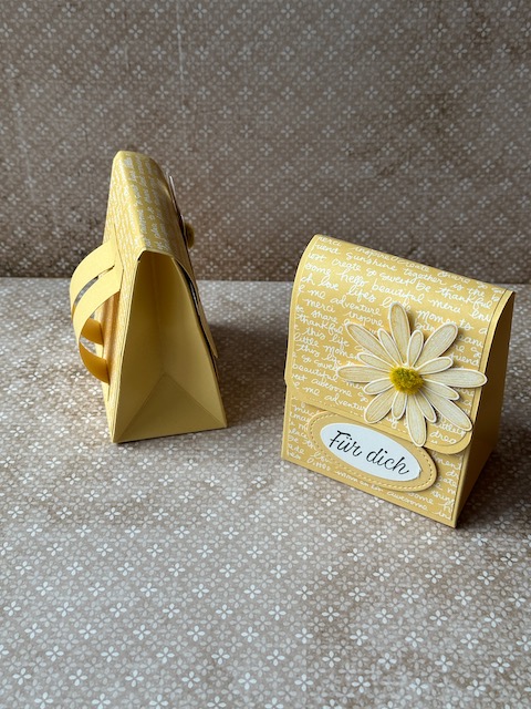 Handgemachter kleiner Rucksack, der an einen Schulranzen erinnert. Die Tasche ist mit einem Designpapier mit Schriftzügen verziert und als Accessoirs sind Gänseblümchen auf der Klappe drapiert. Ergänzt wird das ganze mit dem Spruch: Für dich und so ist dieser kleine Schulranzen nicht nur ein Geschenk zur Einschulung, sondern auch ein ganz persönliches Geschenk zu jeglichem Anlass