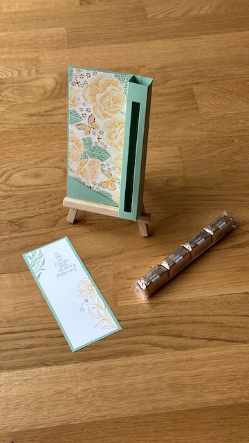 Zu sehen ist eine Verpackung für einen Schokoladenstick mit einer eingesteckten Karte, die man auch als Lesezeichen weiter verwenden könnte. 