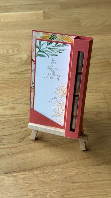 Zu sehen ist eine Verpackung für einen Schokoladenstick mit einer eingesteckten Karte, die man auch als Lesezeichen weiter verwenden könnte.