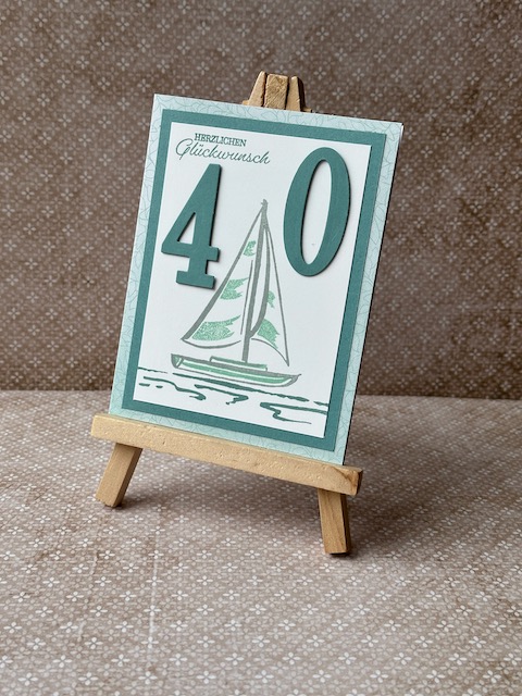 Zu sehen ist eine Geburtstagskarte in grün Tönen mit einem gestempelten Segelboot und Herzlichen Glückwunsch drauf. Zum 40. Geburtstag