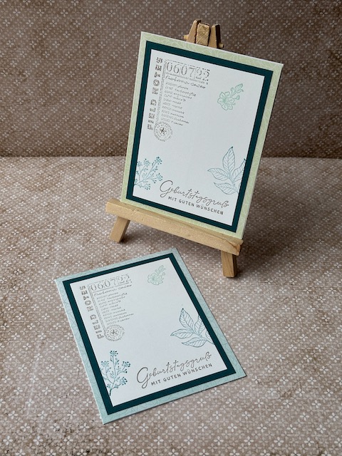 Gebastelte Geburtstagskarte mit mittgrüner Grundkarte und Smaragd-Layer, weißer Deckseite mit Eckstempel, grünen Blüten und Blättern am Rand, Variante mit Zahlen 70 und 100, handgefertigtes Unikat.