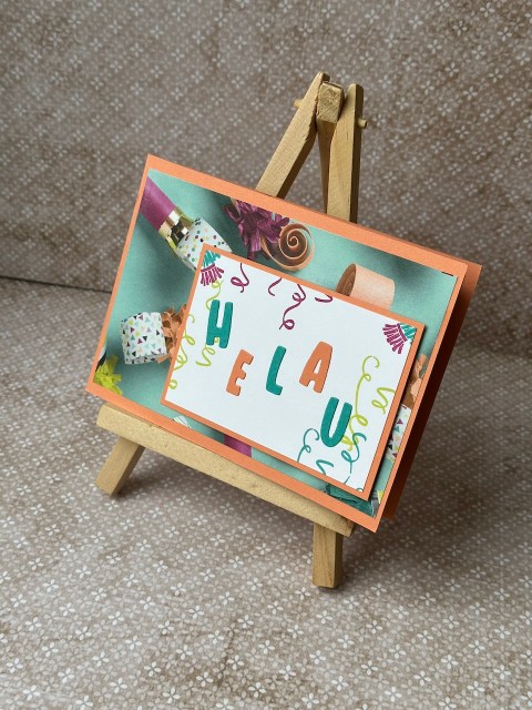 Zu sehen ist eine selbstgebastelte Tunnelkarte. Vorne sind die Buchstaben für das Wort Helau in loser Reihenfolge aufgeklebt. Öffnet man die Tunnelkarte, dieht man ganz viele Punkte, Pfeifen und Partygirlanden passend zum Karneval.